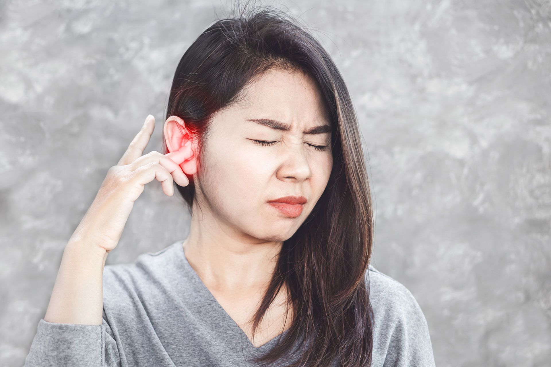 The image shows a woman with her hand on her ear, possibly indicating she s experiencing discomfort or pain, with an overlaid text that reads  alt .